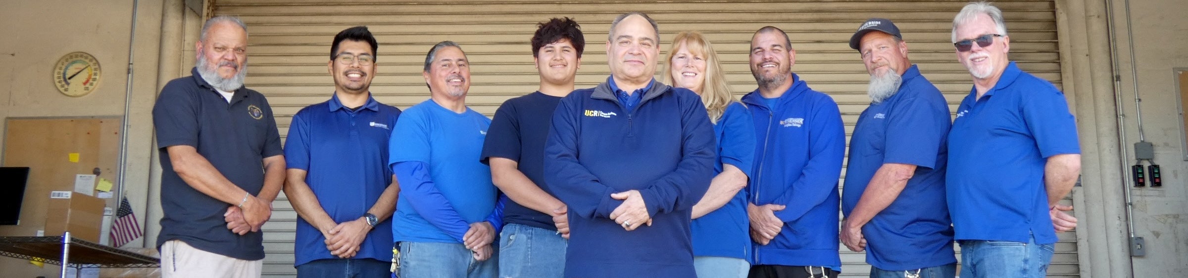 The Receiving Services team stands on the receiving dock.