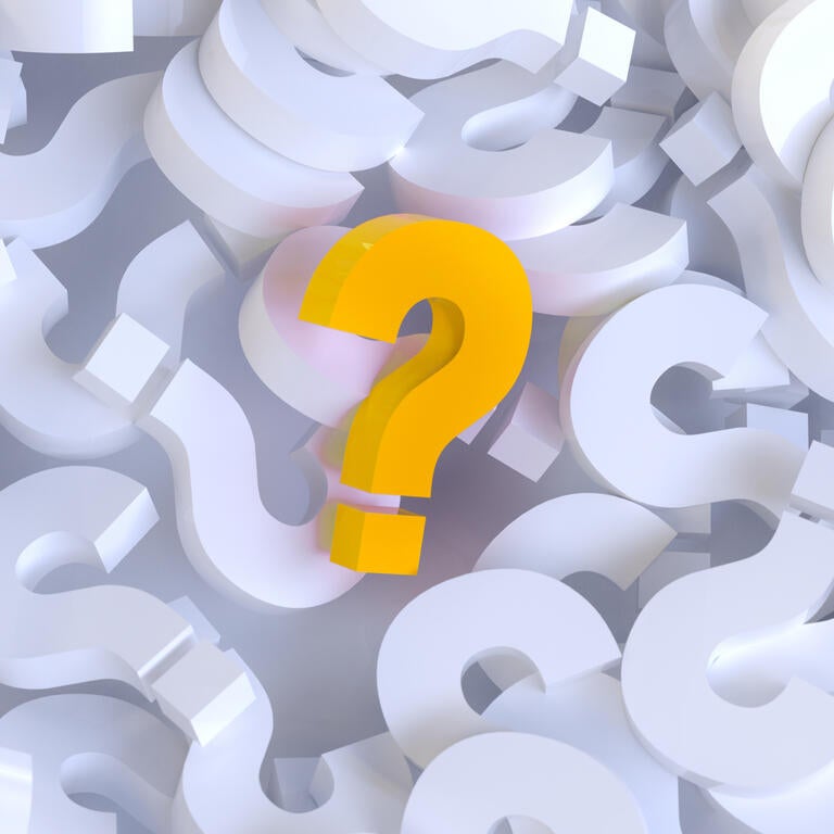 Yellow question mark in a pile of white question marks